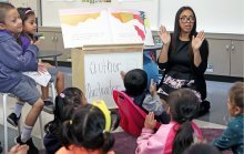 Teacher with students in large group time
